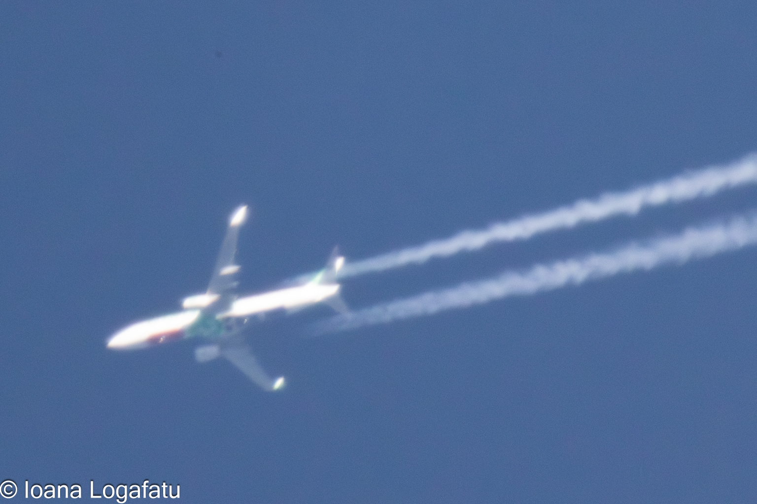 Airplane soaring high in a clear blue sky